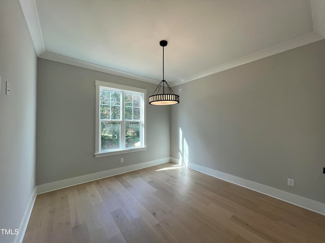 empty room with light hardwood / wood-style floors and ornamental molding