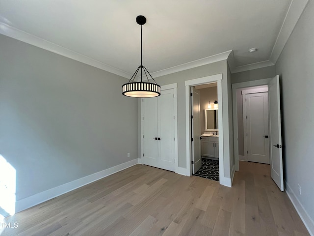 unfurnished dining area with light hardwood / wood-style flooring and ornamental molding