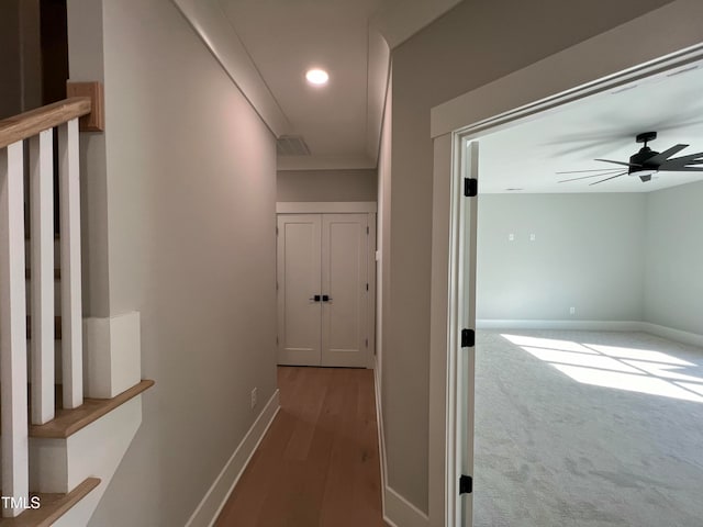 corridor with wood-type flooring and ornamental molding