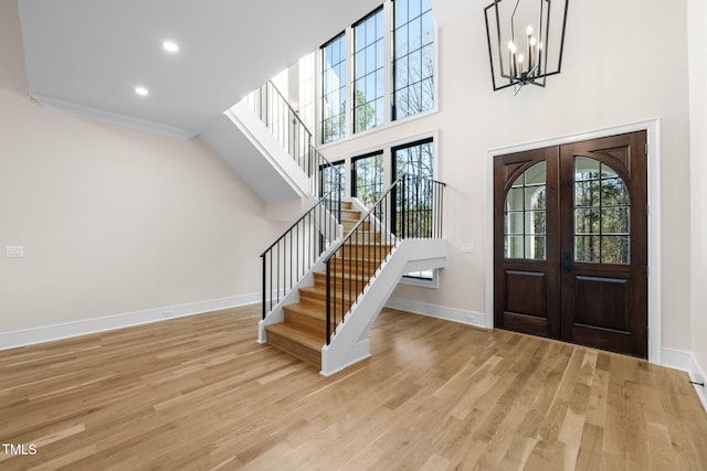 foyer with a chandelier, french doors, light hardwood / wood-style flooring, and plenty of natural light