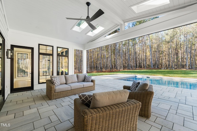 sunroom / solarium with lofted ceiling with skylight and ceiling fan