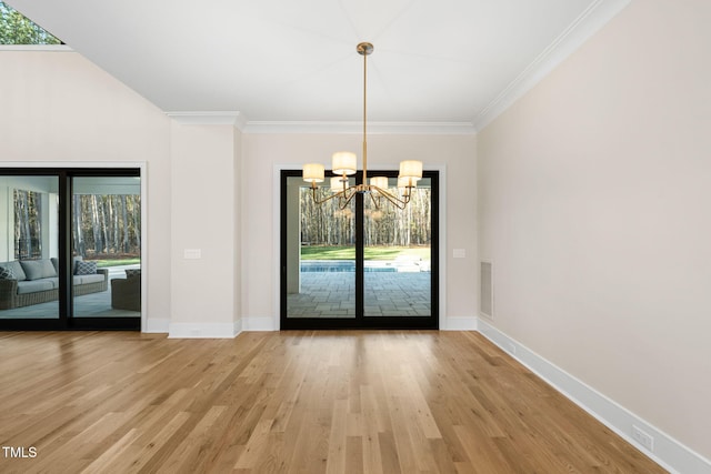 unfurnished dining area featuring light hardwood / wood-style flooring, an inviting chandelier, plenty of natural light, and ornamental molding