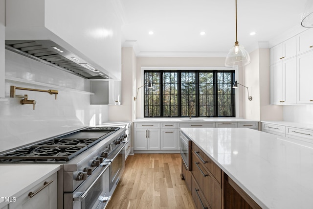 kitchen featuring light hardwood / wood-style floors, light stone counters, white cabinetry, and appliances with stainless steel finishes