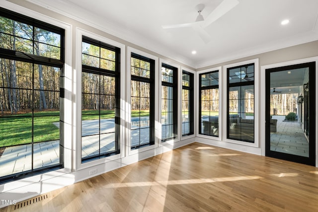 doorway to outside featuring light wood-type flooring, ceiling fan, and crown molding