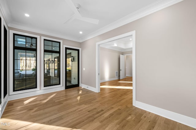 spare room featuring crown molding and wood-type flooring