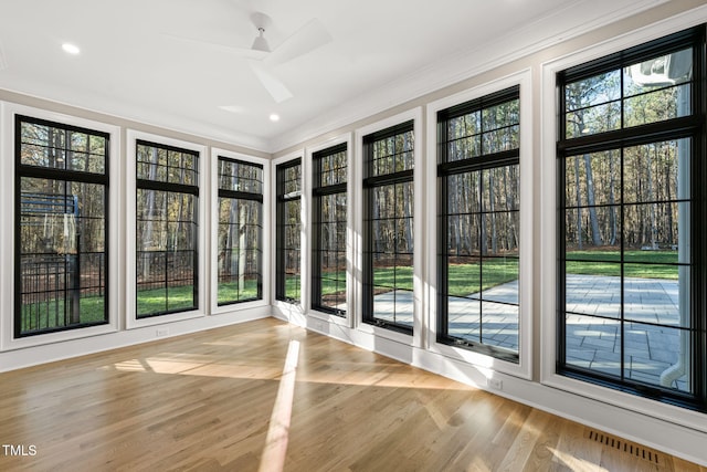 unfurnished sunroom with ceiling fan