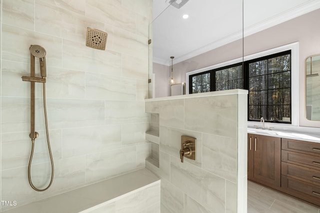 bathroom with vanity, a tile shower, and crown molding