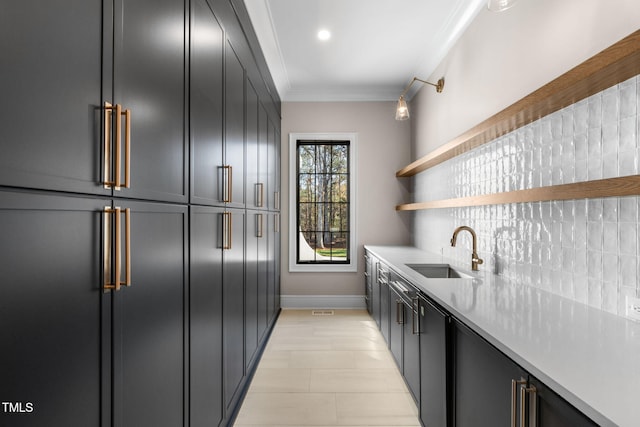 kitchen with decorative backsplash, ornamental molding, and sink