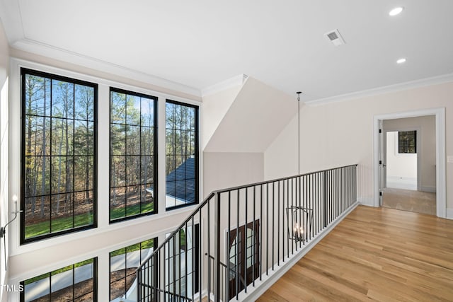 hallway featuring plenty of natural light, light hardwood / wood-style floors, and crown molding