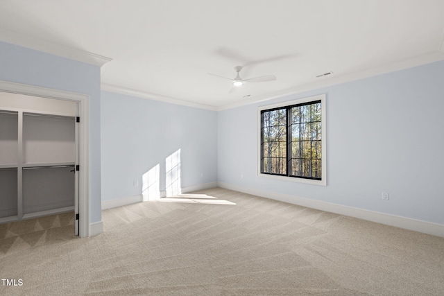 unfurnished bedroom featuring a closet, ceiling fan, crown molding, and light carpet