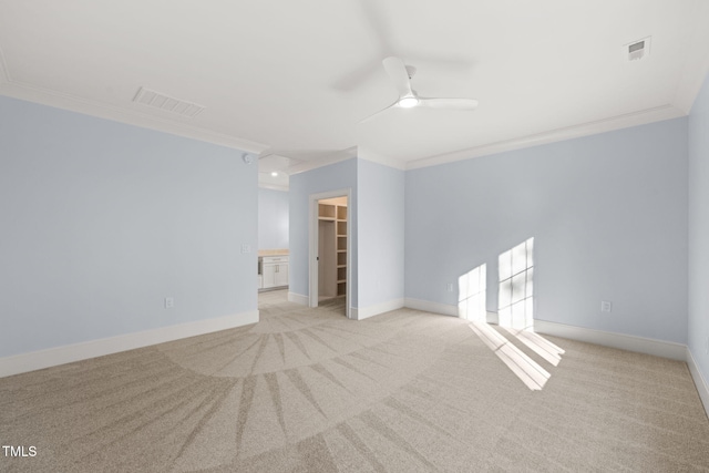 unfurnished room featuring ceiling fan, ornamental molding, and light carpet