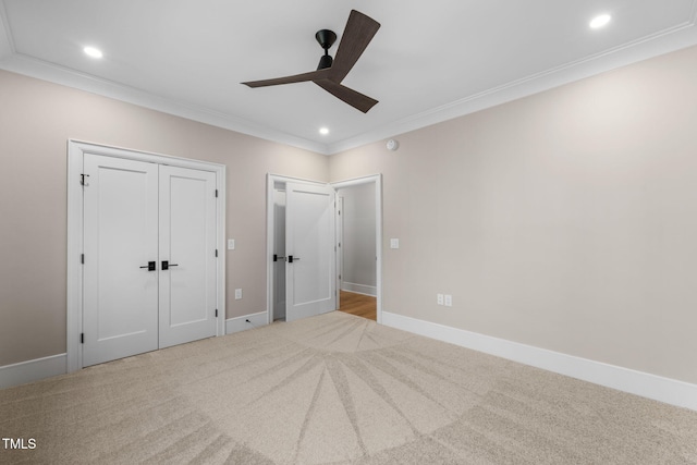 unfurnished bedroom with ceiling fan, crown molding, and light colored carpet