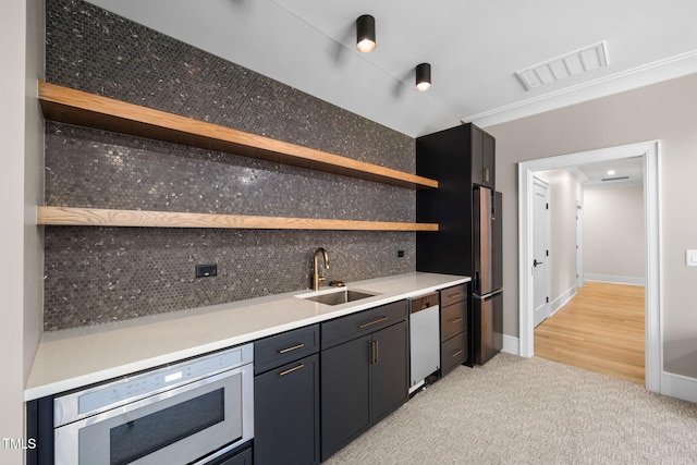 kitchen with sink, tasteful backsplash, stainless steel fridge, white dishwasher, and light hardwood / wood-style floors