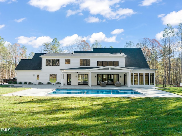 rear view of property featuring a yard, an outdoor living space, and a patio area