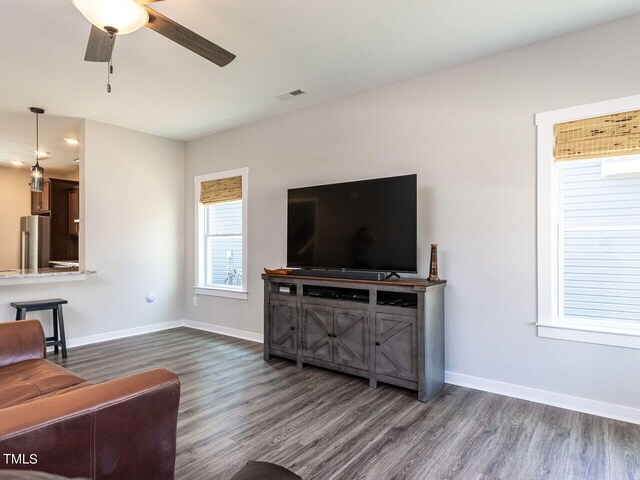 living room featuring ceiling fan and dark wood-type flooring