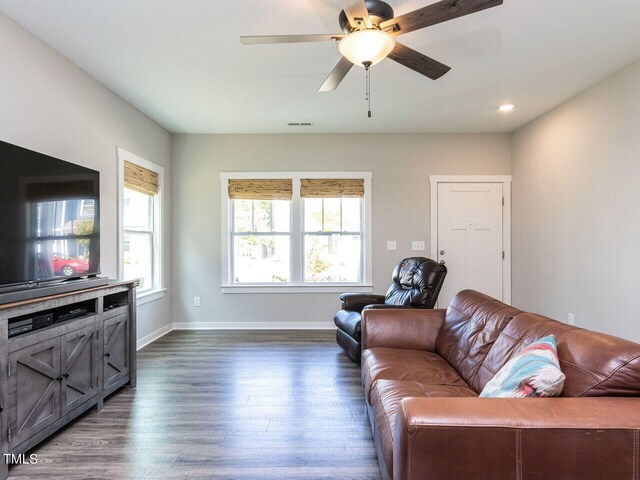 living room with dark hardwood / wood-style floors and ceiling fan