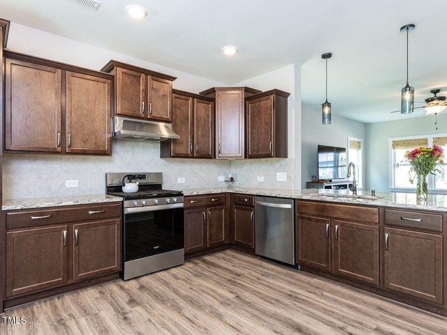 kitchen with ceiling fan, sink, hanging light fixtures, light hardwood / wood-style flooring, and appliances with stainless steel finishes