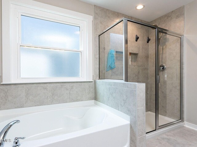 bathroom with tile patterned floors and independent shower and bath