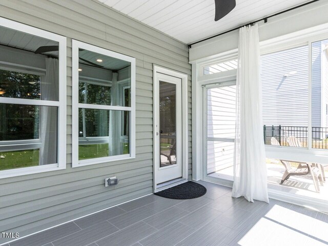 unfurnished sunroom with ceiling fan