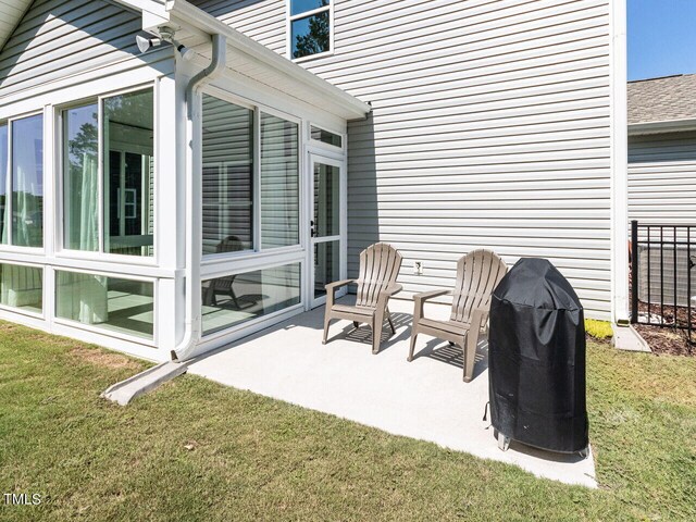 view of patio with area for grilling and a sunroom