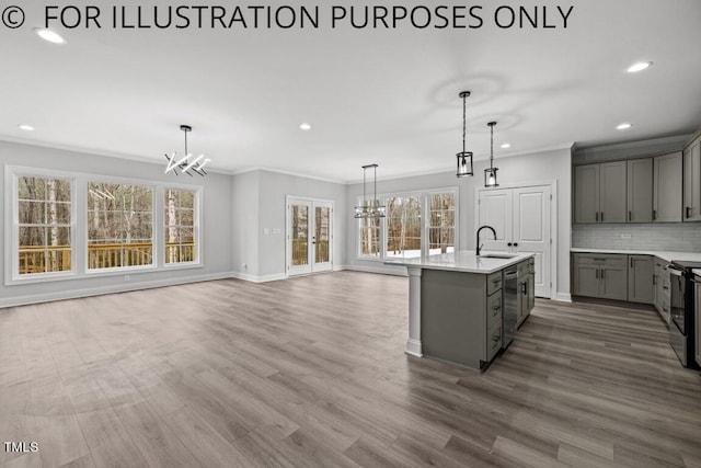 kitchen with dark hardwood / wood-style flooring, ornamental molding, a center island with sink, and sink