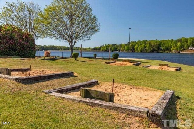 view of home's community with a water view and a yard