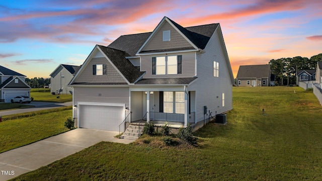 view of front of home with a yard, a porch, a garage, and central AC