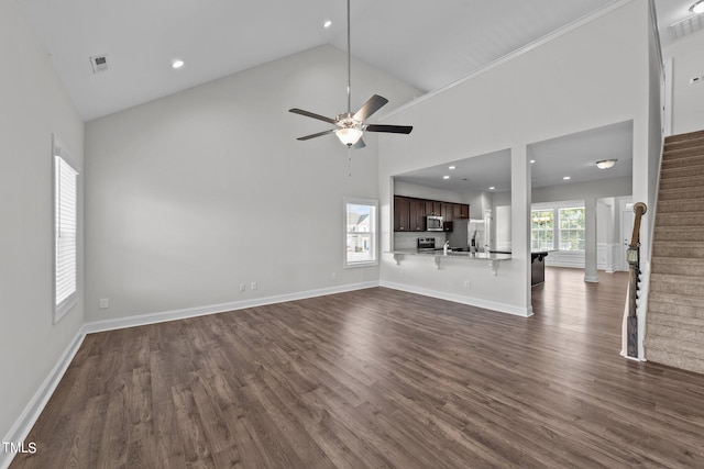 unfurnished living room with high vaulted ceiling, dark hardwood / wood-style floors, sink, and ceiling fan