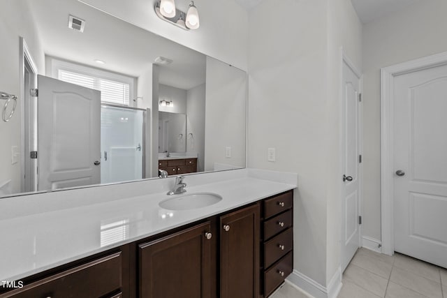 bathroom featuring tile patterned flooring, vanity, and walk in shower