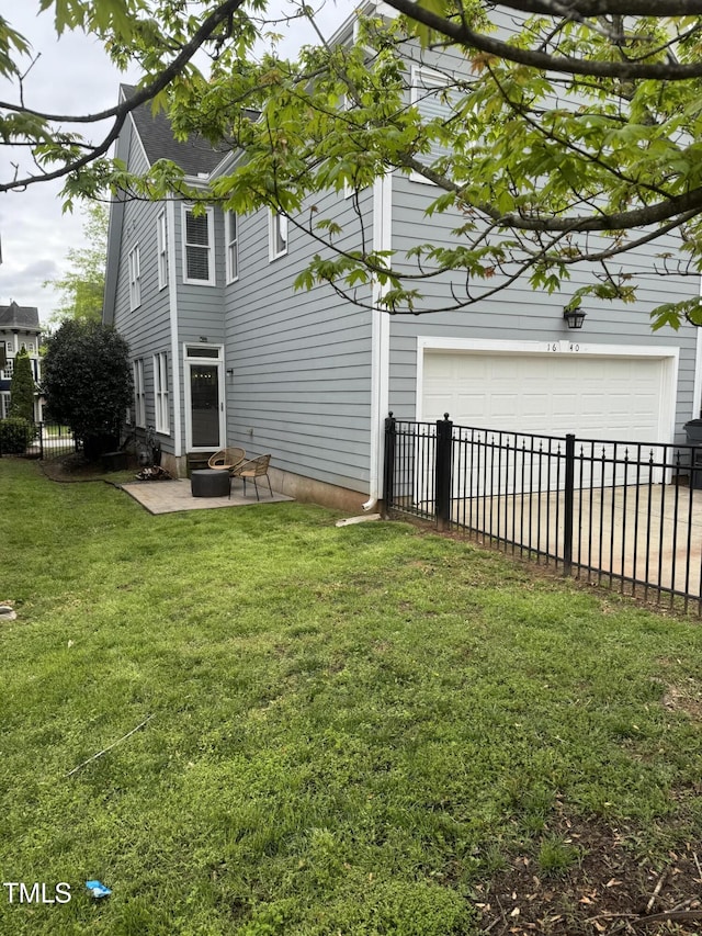 rear view of house with a garage, a patio area, fence, and a lawn