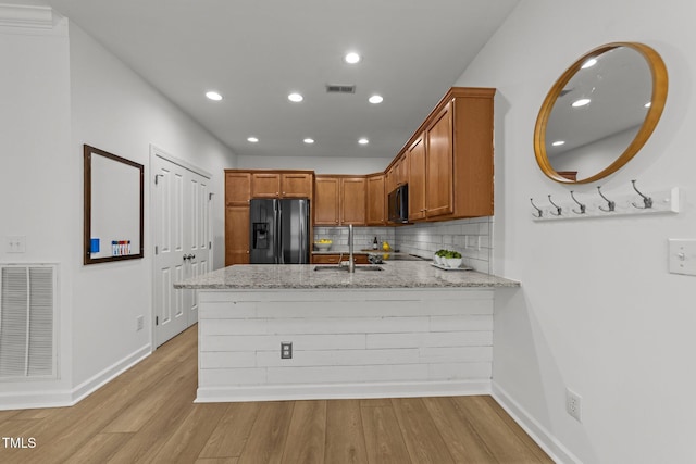 kitchen with a sink, visible vents, black appliances, and a peninsula