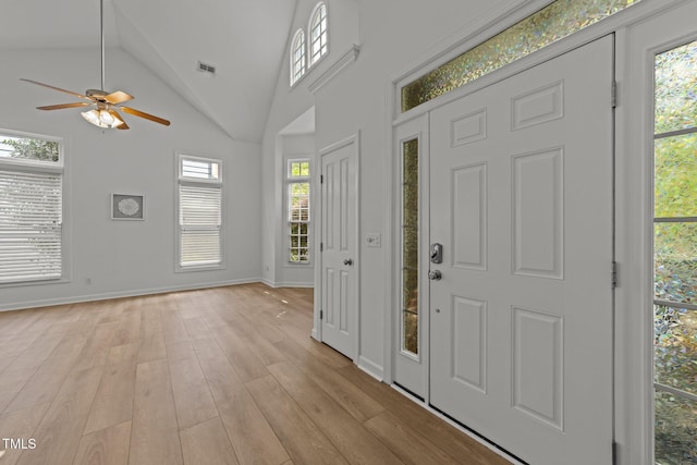entryway featuring a ceiling fan, visible vents, lofted ceiling, light wood finished floors, and baseboards