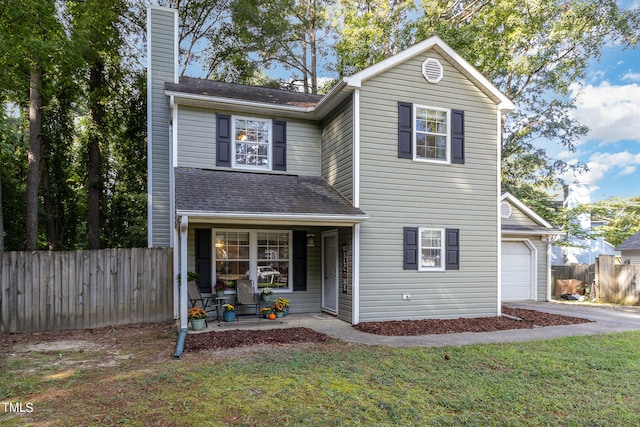 front facade featuring a garage, a front yard, and covered porch