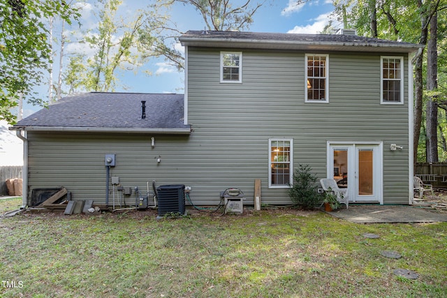 rear view of house with a yard and central AC unit