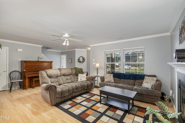 living room featuring ceiling fan, light hardwood / wood-style floors, and crown molding