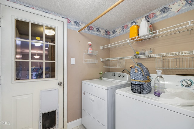 laundry area with a textured ceiling and separate washer and dryer