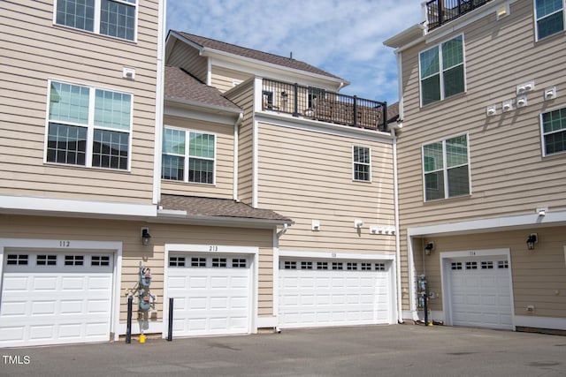 view of side of home with a balcony and a garage