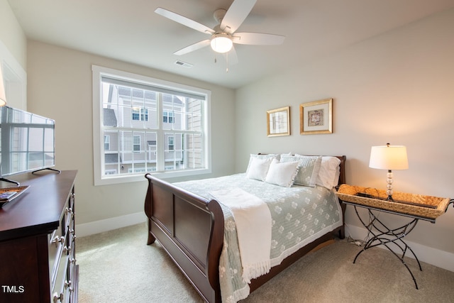 carpeted bedroom featuring multiple windows and ceiling fan