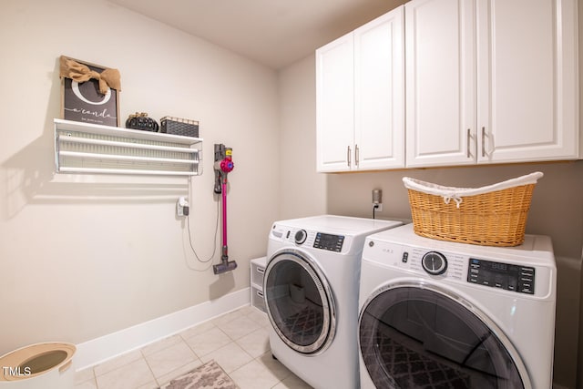 laundry area with light tile patterned floors, cabinets, and washer and dryer