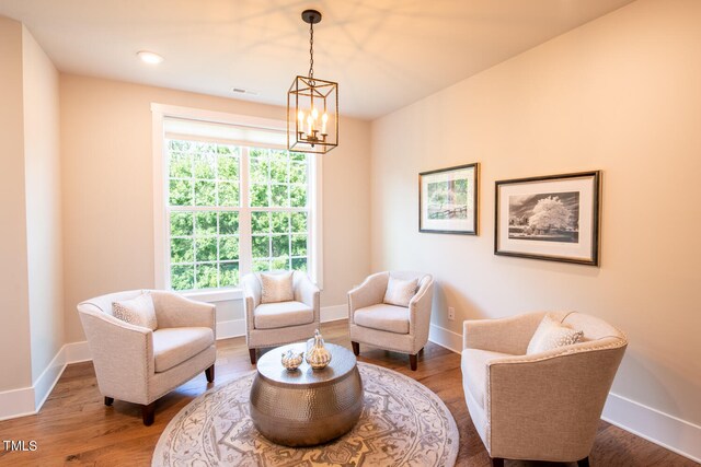 sitting room with wood-type flooring and a notable chandelier