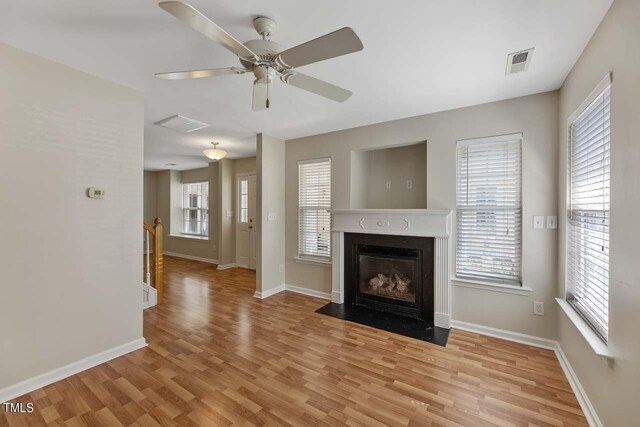 unfurnished living room with a wealth of natural light, light hardwood / wood-style floors, and ceiling fan