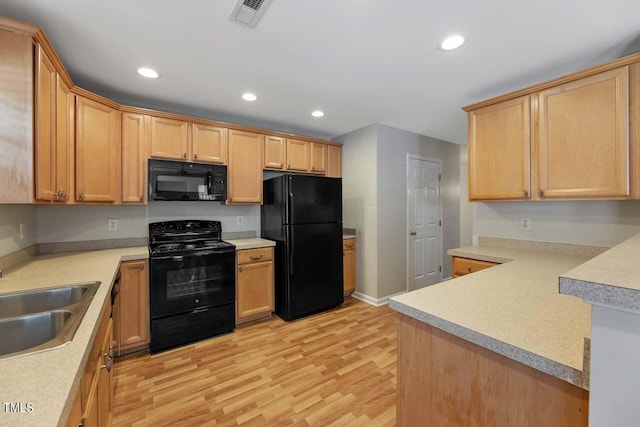 kitchen featuring sink, kitchen peninsula, light hardwood / wood-style flooring, black appliances, and light brown cabinetry