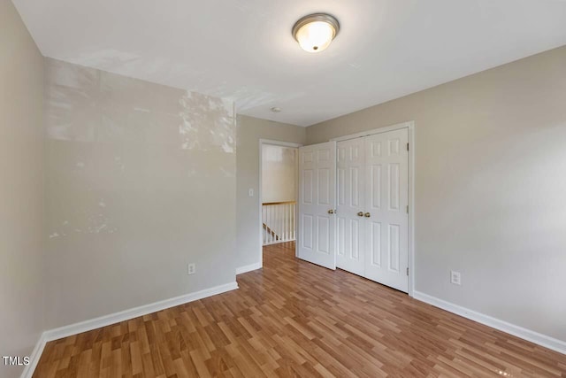 unfurnished bedroom with light hardwood / wood-style flooring and a closet