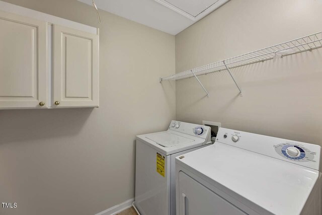 washroom with washing machine and clothes dryer and cabinets