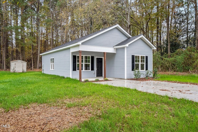 view of front of house with a front yard and a storage shed