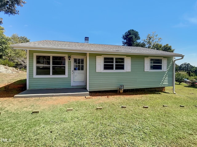 view of front facade featuring a front yard and a shingled roof