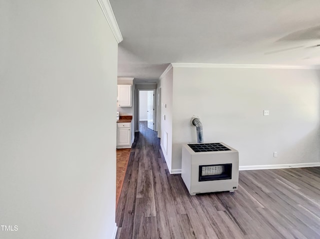 corridor with crown molding, hardwood / wood-style floors, and heating unit