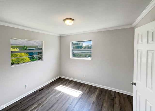 empty room with ornamental molding, plenty of natural light, and dark hardwood / wood-style floors