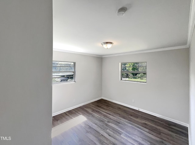 unfurnished room featuring ornamental molding, baseboards, and dark wood-style flooring