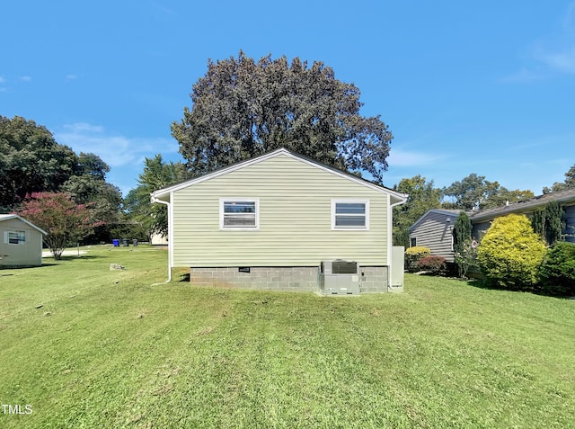 view of property exterior with a yard and central AC